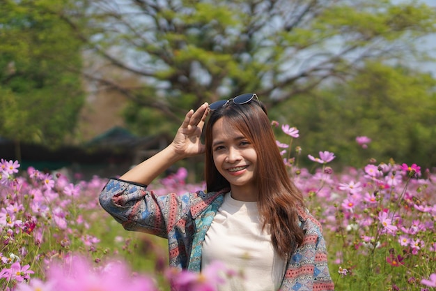 Happy Asian woman in cosmos flower garden