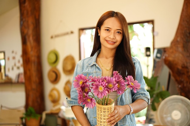 Happy Asian woman holding a coffee shop holding flowers