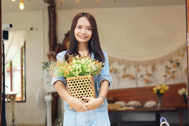 Happy Asian woman holding a coffee shop holding flowers