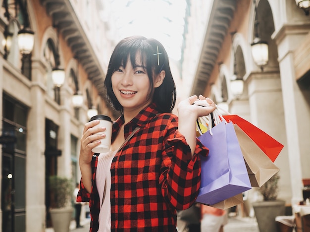 Happy Asian woman holding shopping bag.