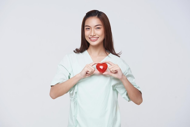 Happy asian woman patient showing heart isolated on white background