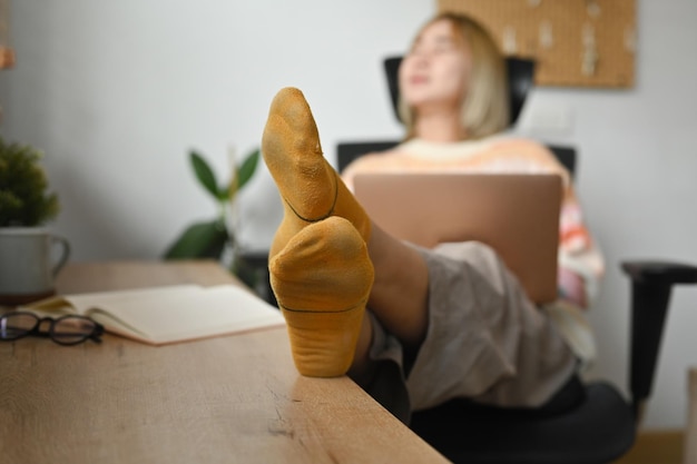 Happy asian woman relaxing and using laptop on comfortable chair at home