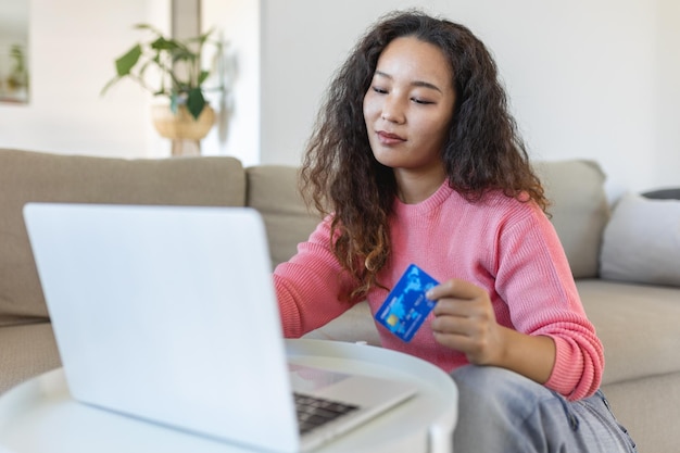 Happy Asian woman shopping online with laptop at home