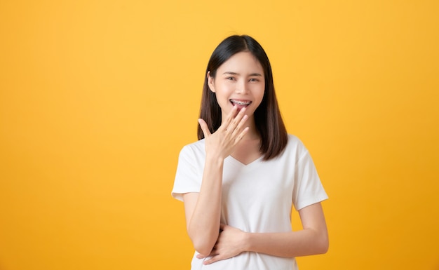 Happy Asian woman on yellow background