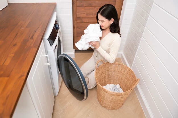 Happy Asian young woman is doing laundry in home healthy lifestyle concept