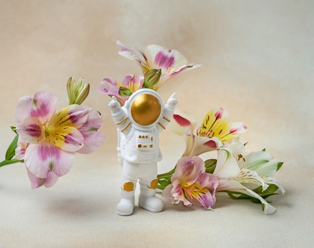 Happy astronaut standing with raised hands surrounded by flowers