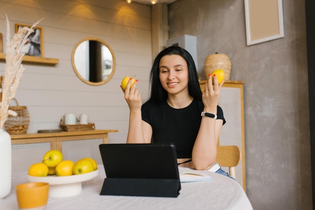 Happy athletic woman blogger fitness trainer or nutritionist holds a video conference on healthy