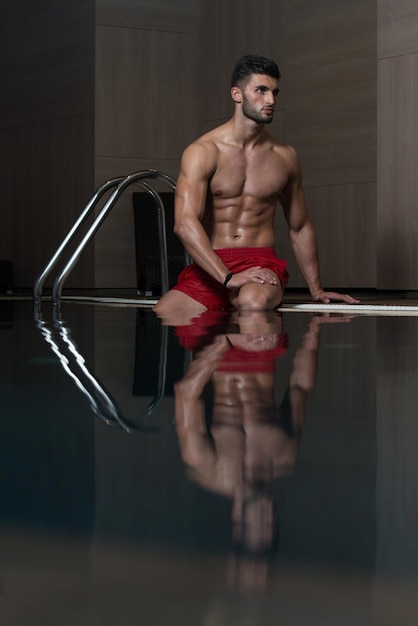 Happy Attractive Man Resting Relaxed On Edge Of Swimming Pool