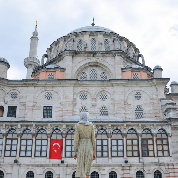 Happy attractive muslim woman near mosque in istanbul turkey posing in courtyard of mosque religion