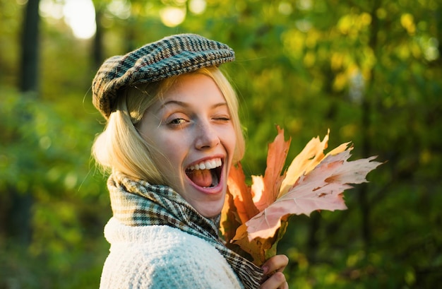 Photo happy autumn girl winking close up portrait autumn outdoor portrait of beautiful happy girl walking in park or forest autumn woman with autumnal mood