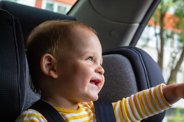 Happy baby boy sitting in car seat