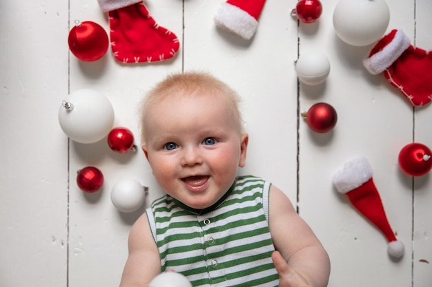 Happy baby celebrating christmas surrounded with toys and decorations