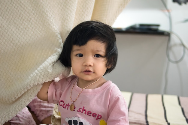 Happy baby girl playing on a bed