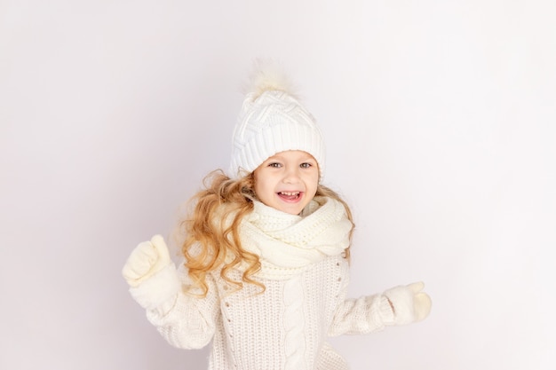 Happy baby girl in warm hat and sweater on white isolated background, space for text