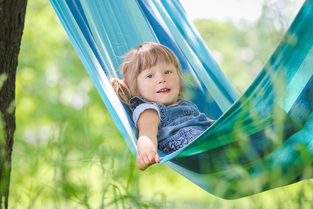 Happy baby in a hammock outdoors in the park