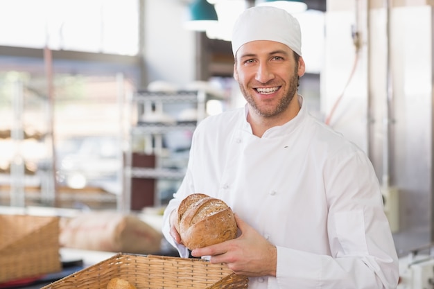 Happy baker with loaf of bread