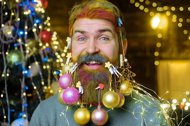 Happy bearded man with decorated beard new year party christmas decorations winter holidays