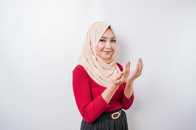 Happy beautiful Asian Muslim girl wearing a headscarf praying to God