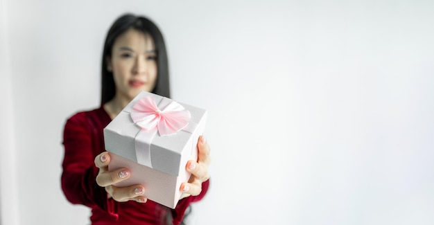 Happy beautiful Asian woman in red dress smile with gift box on white background Receiving gifts from lovers New Year Christmas and Valentines Day concept