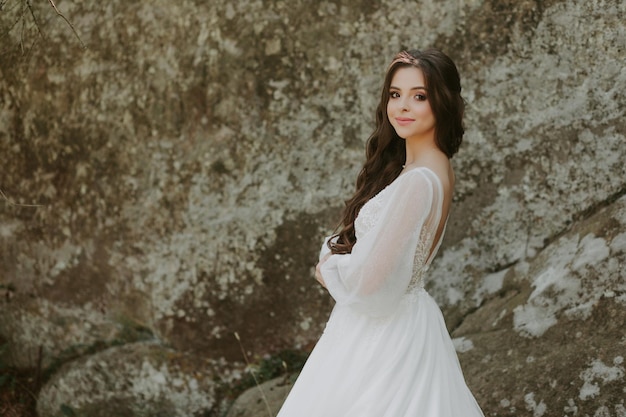 Happy beautiful bride outside on a summer meadow at the sunset with perfect view