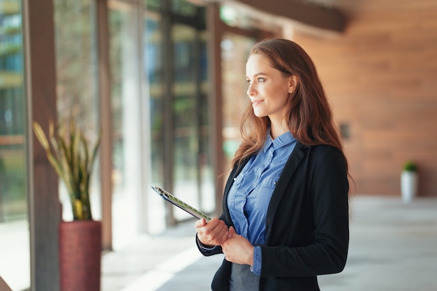 Happy beautiful business woman with clipboard in the office.