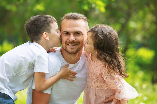 Happy beautiful family together father son and daughter portrait on a walk on a Sunny summer day