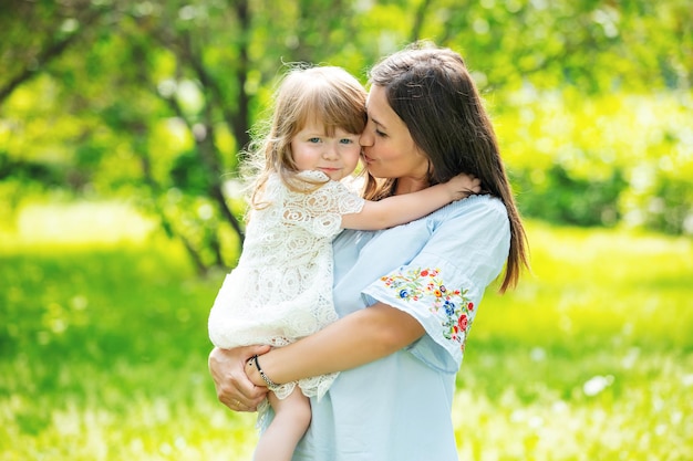 Happy beautiful family together mother and daughter portrait on the grass on a Sunny summer day