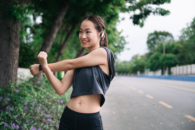 Happy beautiful girl stretching arm before jogging