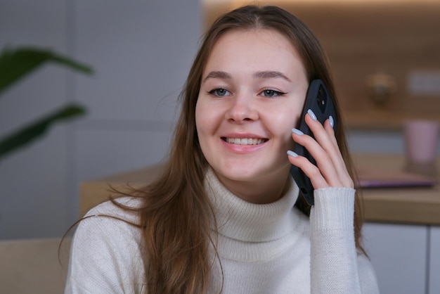 Happy beautiful girl young woman talking on cell mobile phone at home smile