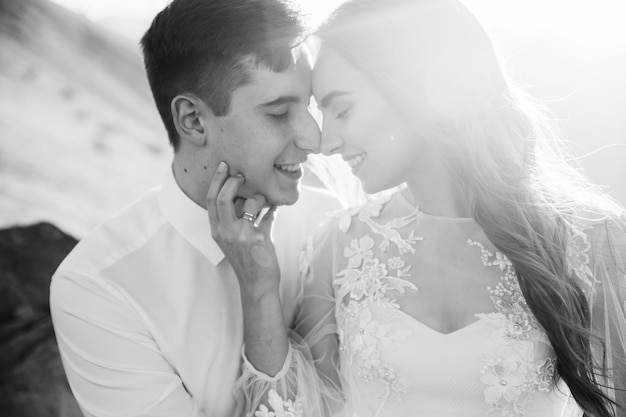 Happy beautiful wedding couple bride and groom at wedding day outdoors on the mountains rock.