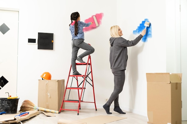 Photo happy beautiful young woman doing wall painting.