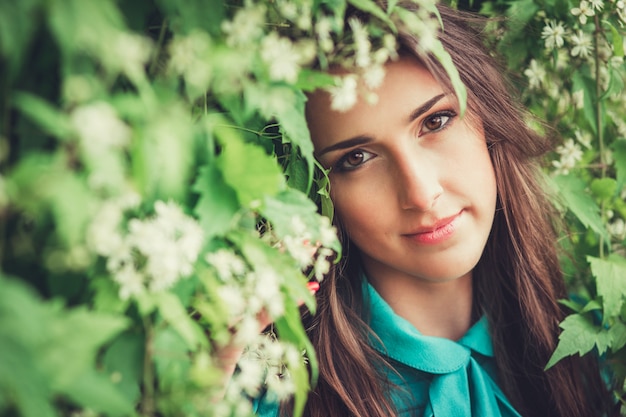 Happy beautiful young woman in spring blossom park. Pretty Girl with Spring Flowers. Fashion Model Outdoors