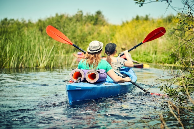 Happy best friends having fun on a kayaks. Kayaking on the river.