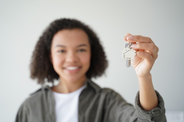 Happy biracial teen girl homeowner tenant shows keys to new home closeup Mortgage rental housing