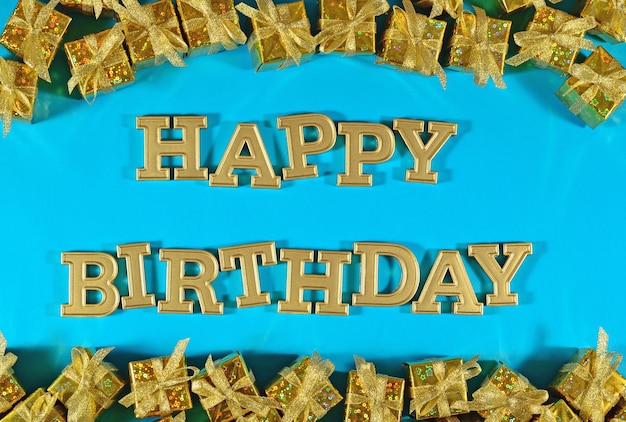 Happy birthday golden text and golden gifts on a blue background