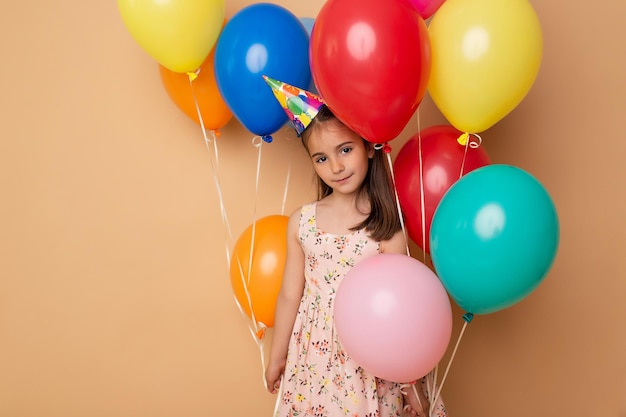 Happy Birthday party Child girl with balloons on beige background