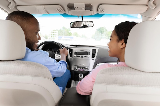 Happy black couple enjoying drive on new car