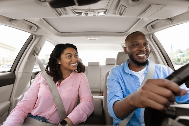 Happy black couple enjoying long drive on a car