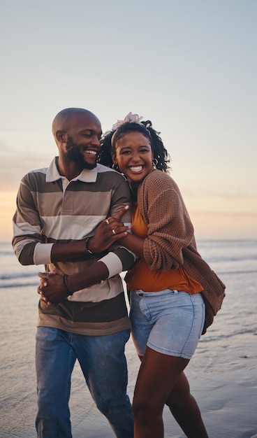 Happy black couple love and beach with smile for vacation in relationship together in the outdoors African American man and woman enjoying bonding time on a ocean coast walk in South Africa