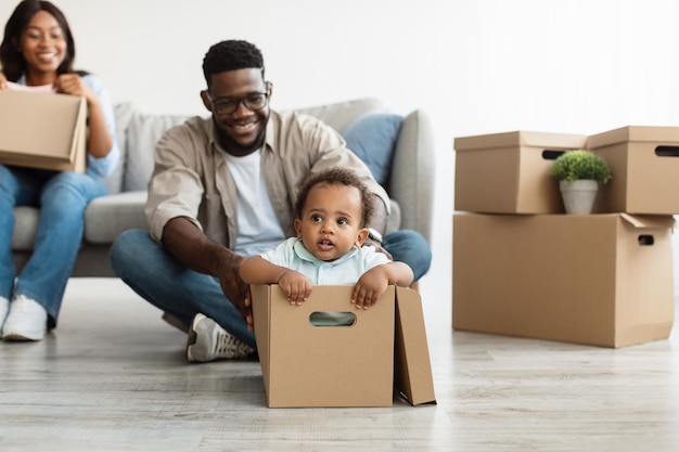 Happy black family celebrating moving day in new apartment