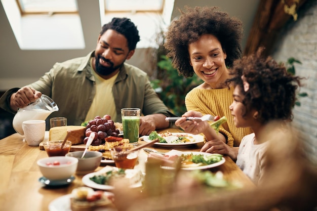 Happy black family having meal together at dining table