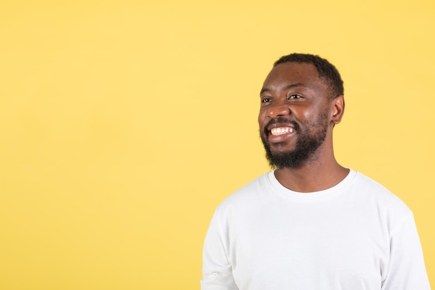 Happy Black Guy Looking Aside At Free Space Yellow Background