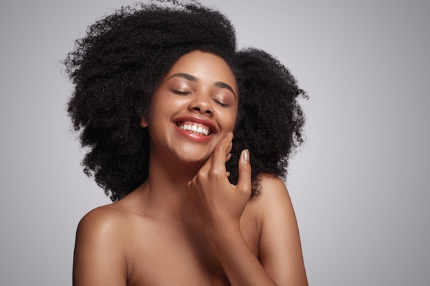 Happy black lady touching soft skin