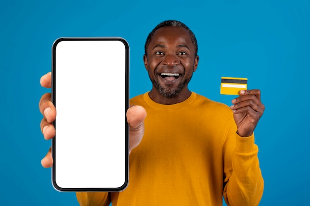 Happy black man holding smartphone and credit card mockup