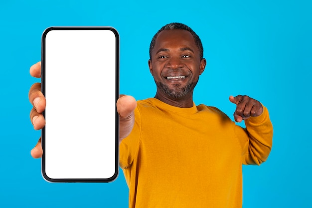 Happy black man pointing at cell phone with blank screen