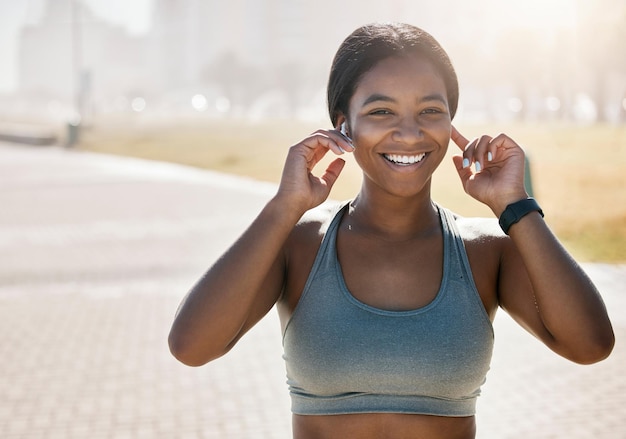 Happy black woman city running and portrait of fitness exercise and sports training at park in morning fog outdoors Marathon runner listening to music for energy workout and wellness motivation