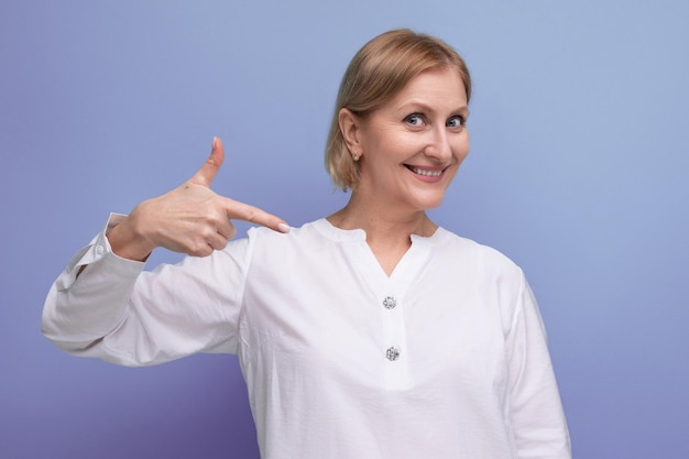 Happy blond middle aged woman in white blouse