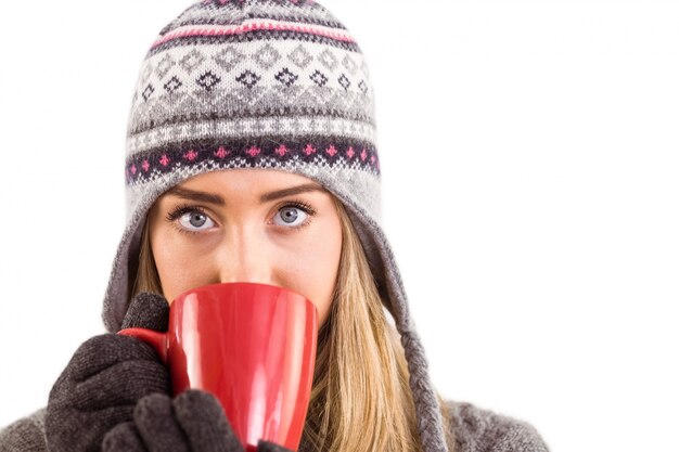 Happy blonde in winter clothes holding mug