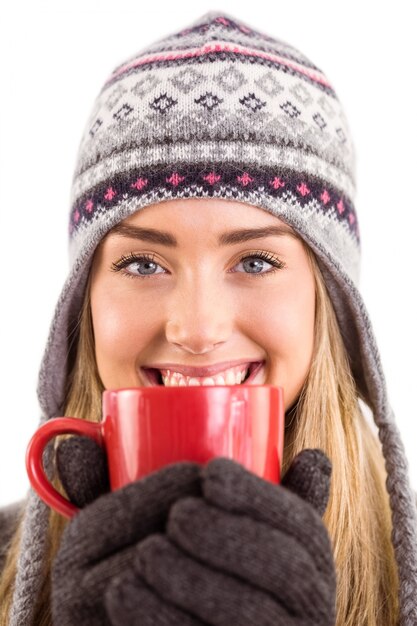 Happy blonde in winter clothes holding mug