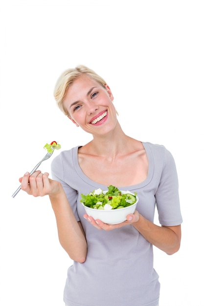 Happy blonde woman holding bowl of salad